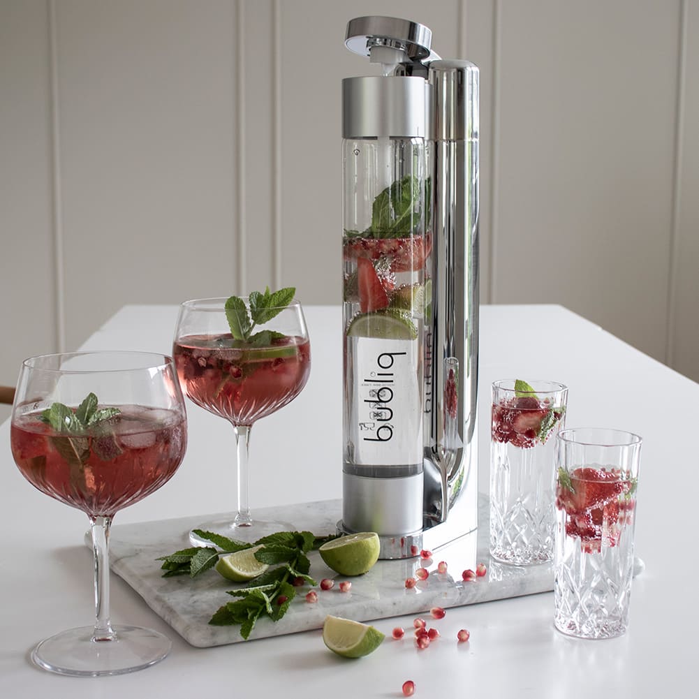 silver bubliq sodavandsmaskine på spisebord med lækre drinks med jordbær