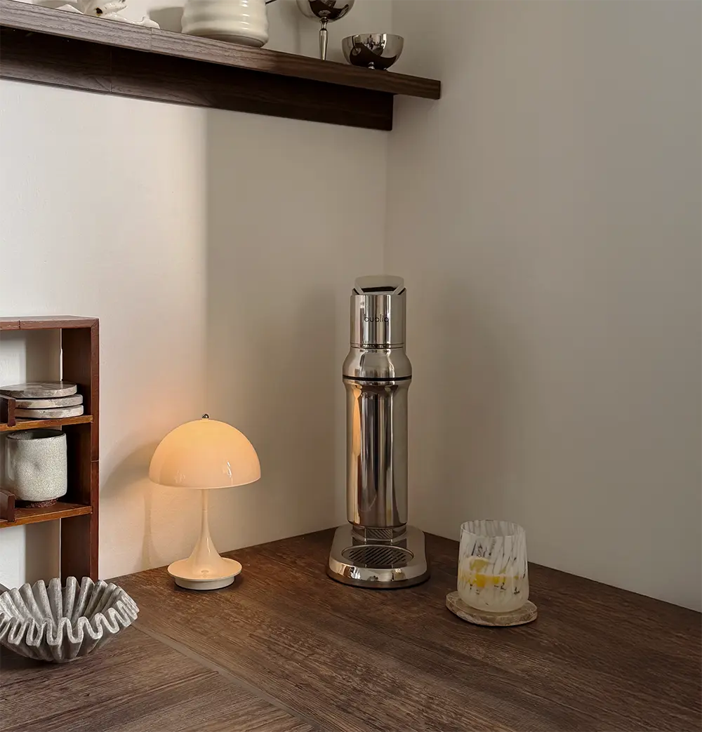 bubliq kulsyremaskine med glasflaske på køkkenbord med et glas danskvand